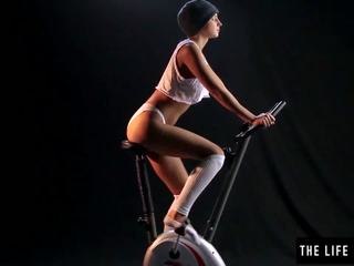 Nekaunīgas sweaty pusaudze slēgumu an exercise bike sēdeklis.
